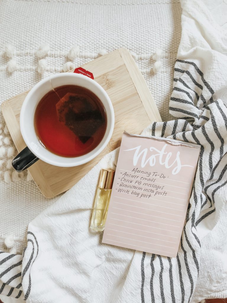 hot cup of tea and a to-do list for waking up early on a pink notepad 