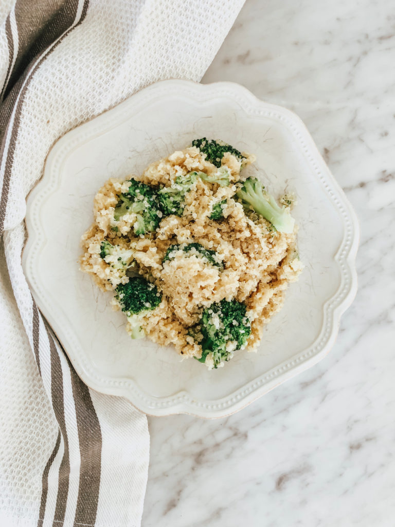 broccoli cheddar quinoa dish on plate on marble counter