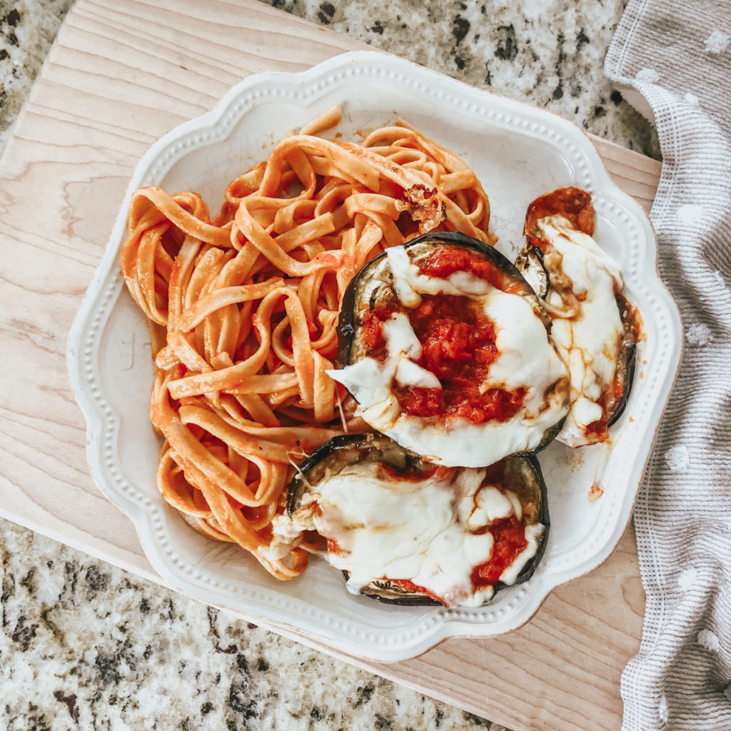 healthy eggplant parm served on plate with pasta 